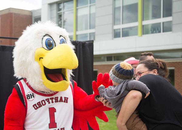 Howie the Hawk mascot greets parents and kids